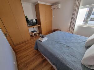 um quarto com uma cama com um edredão azul em Brisa Atlântica em Portimão