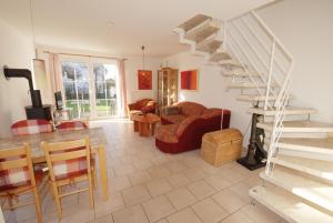 a living room with a table and a spiral staircase at Haus Albatros in Dorum-Neufeld