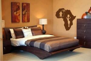 - une chambre avec un grand lit et une commode dans l'établissement Christina Residence, à Dar es Salaam