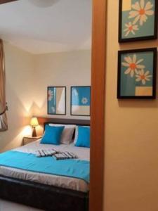 1 dormitorio con 1 cama con sábanas azules y cuadros en la pared en Modern, 1 Bed Apt, 4* Vineyards, en Kableshkovo