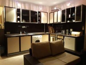 una cocina con armarios blancos y un sofá en una habitación en Modern, 1 Bed Apt, 4* Vineyards, en Kableshkovo