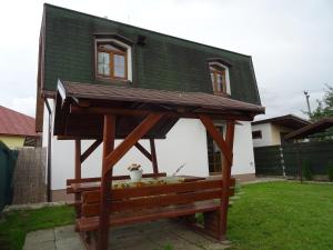una pequeña casa con un banco en un patio en Rekreačný dom Tyrkys, en Poprad