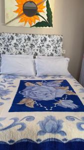 um quarto com uma cama com um cobertor azul e branco em Pousada Simone em Cambará