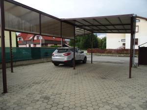 ein kleines silbernes Auto, das unter einem überdachten Parkplatz parkt in der Unterkunft Rekreačný dom Tyrkys in Poprad