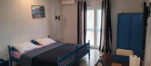 a bedroom with a bed and a blue cabinet and a window at STUDIO APARTMANI KIKI in Srima