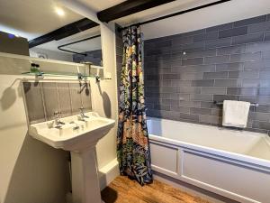 a bathroom with a sink and a bath tub at The Old Mill in Salisbury