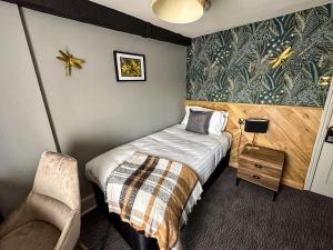 a small bedroom with a bed and a chair at The Old Mill in Salisbury