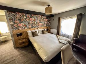 1 dormitorio con 1 cama grande y pared de flores en The Old Mill, en Salisbury