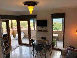 a living room with a table and chairs and a television at La Finestra sulla Torre in Stintino
