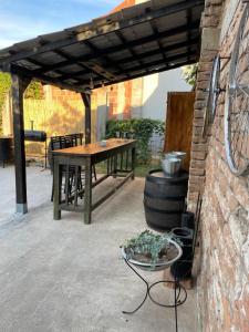 a patio with a wooden table and a brick wall at Bela Vila in Negotin