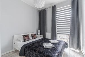 a bedroom with a bed with two towels on it at Grobla by Loft Apartments in Gdańsk