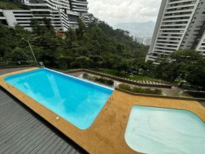 a large blue swimming pool on top of a building at Apartamento con vista a Medellín in Medellín