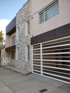 un edificio con dos puertas de garaje a un lado en Quilimbai Departamentos Turísticos en Malargüe