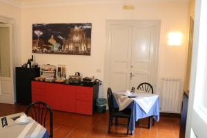 カターニアにあるL'elefanteのキッチン(赤いドレッサー、テーブル、椅子付)