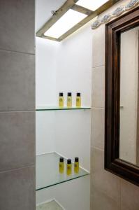 a bathroom with glass shelves and a mirror at Kolimpithres beach house in Naousa