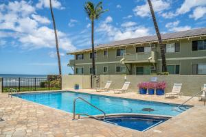 una piscina frente a un edificio con palmeras en Shores of Maui 121, en Kihei