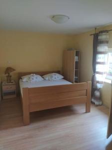 um quarto com uma cama com duas almofadas em House with the ecogarden at the end of the Village em Čitluk