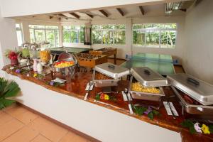 uma grande cozinha com várias mesas de buffet com comida em Manzanillo Caribbean Resort em Puerto Viejo