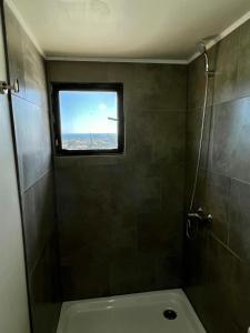 ein Bad mit einer Dusche und einem WC mit einem Fenster in der Unterkunft Golondrina El Tabo in Las Cruces