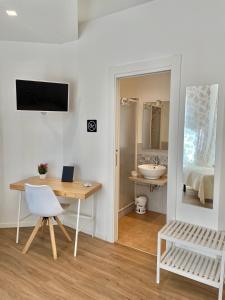Habitación con escritorio, mesa y espejo. en Catalogna10 Rooms en Alghero