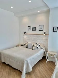 1 dormitorio con 1 cama grande y pared blanca en Catalogna10 Rooms en Alghero