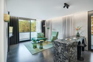 een woonkamer met een tafel, een bank en een stoel bij Das Royal in Bad Füssing