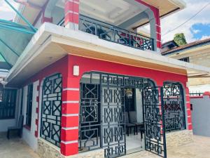 a red building with black doors and a balcony at SR Apartments Milimani, Kisumu in Kisumu