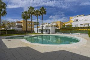 una piscina con palme e edifici di ÁTICO ATALAYA Parking privado gratis ad Ayamonte