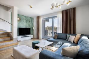 Luxury Apartment Stilla في بليد: غرفة معيشة مع أريكة زرقاء وتلفزيون