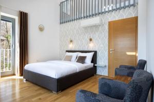 Luxury Apartment Stilla في بليد: غرفة نوم فيها سرير وكرسيين