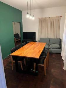 a living room with a wooden table and a couch at El pasillo Centro in Rosario