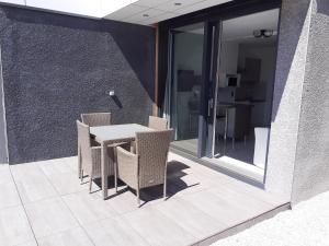 um pátio com uma mesa e cadeiras num edifício em Esperanza em Cap d'Agde