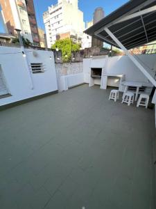 Un balcón con mesas blancas y sillas en un edificio en El pasillo Centro en Rosario