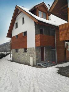 une maison avec de la neige devant elle dans l'établissement Apartmán Mýto, à Mýto pod Ďumbierom