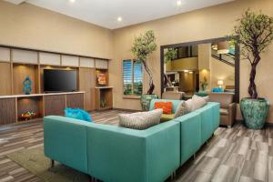 un salon avec un canapé bleu et une télévision dans l'établissement Holiday Inn Phoenix/Chandler, an IHG Hotel, à Chandler