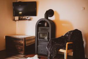 a room with a fireplace and a person sitting in a chair at Vándor Tanya in Ágasegyháza