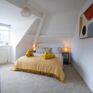 a white bedroom with a large bed with yellow pillows at Moor View Apartment, near city centre and stadium in Town Moor
