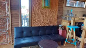 sala de estar con sofá azul y taburete en Cabañas & SPA Carilafquen, en Laguna Verde