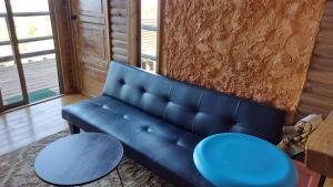 a blue couch and two tables in a room at Cabañas & SPA Carilafquen in Laguna Verde