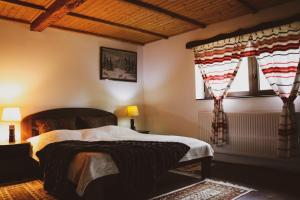 a bedroom with a large bed and two windows at Vándor Tanya in Ágasegyháza