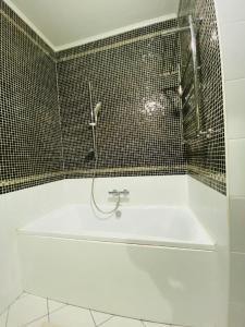 a bathroom with a bath tub with a shower at Апартаменты 2 комнатная возле теннисного центра in Aktobe