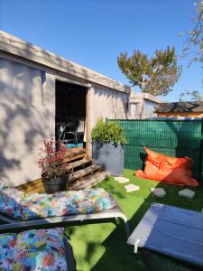 einen Hinterhof mit einem Schuppen und einer Terrasse mit Gras in der Unterkunft Mobil Home neuf Hyères in Hyères