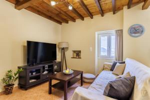 a living room with a couch and a flat screen tv at Villa Nirvana in Skopelos Town +20 photos