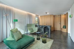 sala de estar con sofá verde y chimenea en Das Royal, en Bad Füssing