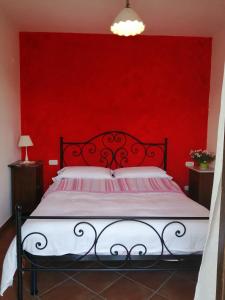 1 dormitorio rojo con 1 cama con pared roja en Agriturismo La Pagliarella, en Caramanico Terme