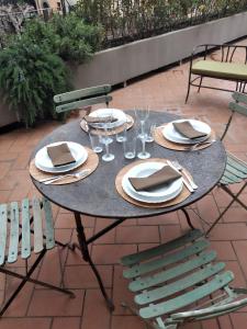 a table with plates and napkins and chairs on a patio at IL DECUMANO CHARME APARTMENTS in Arezzo
