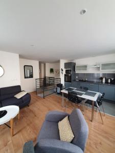 a living room with a couch and a table at Appartement de Thomas in Charleville-Mézières