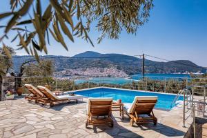 斯科派洛斯Villa Nirvana的一个带椅子的游泳池,享有水景
