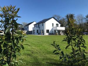 a large white house in a field of grass at Ashlee Lodge P25 K6R6 in Shanagarry