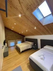 a bedroom with two beds and a skylight at Bujtina Apsus in Berat